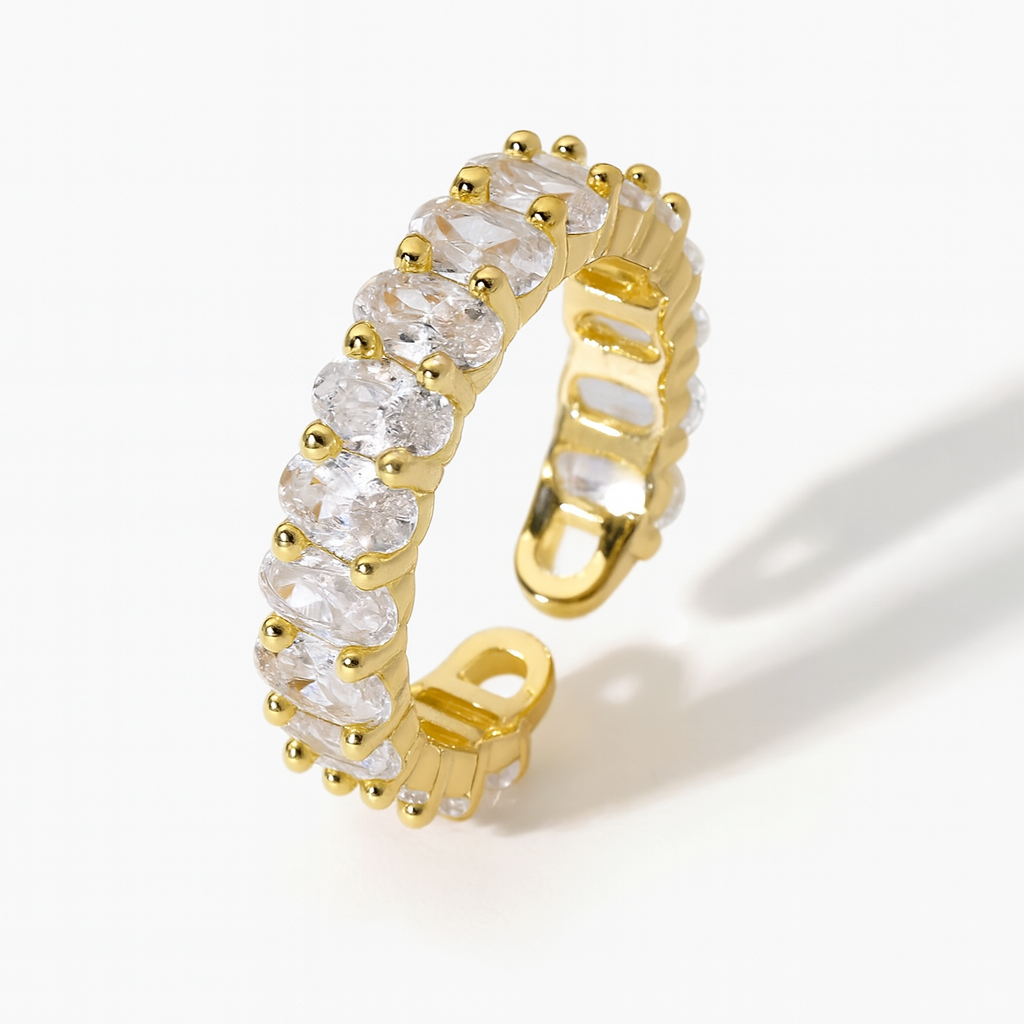 Gold ring with clear gemstones on a white background